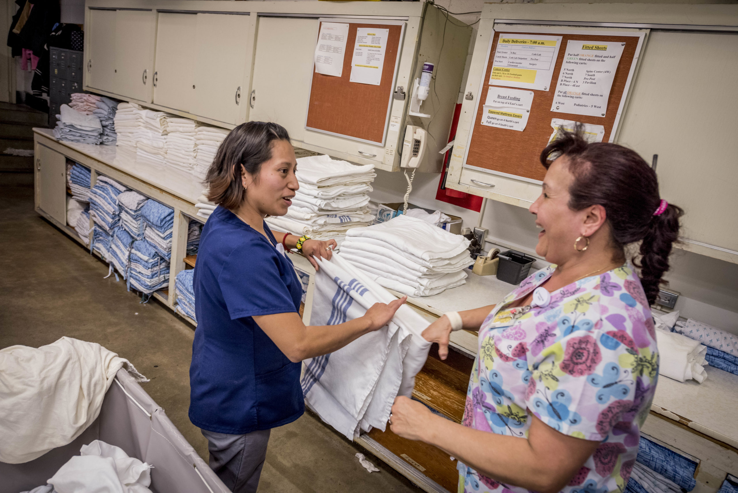 employees folding clean hospital bedding