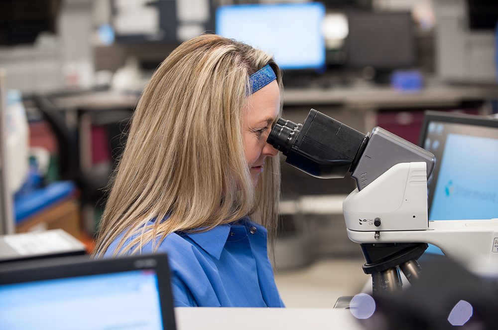 a pathologist looking into microscopes