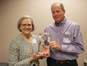 Two people holding an award