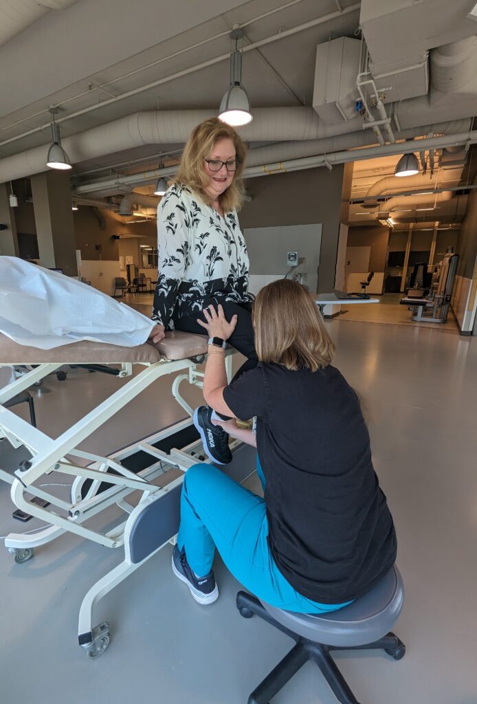 A women getting help with a physical therapy exercise